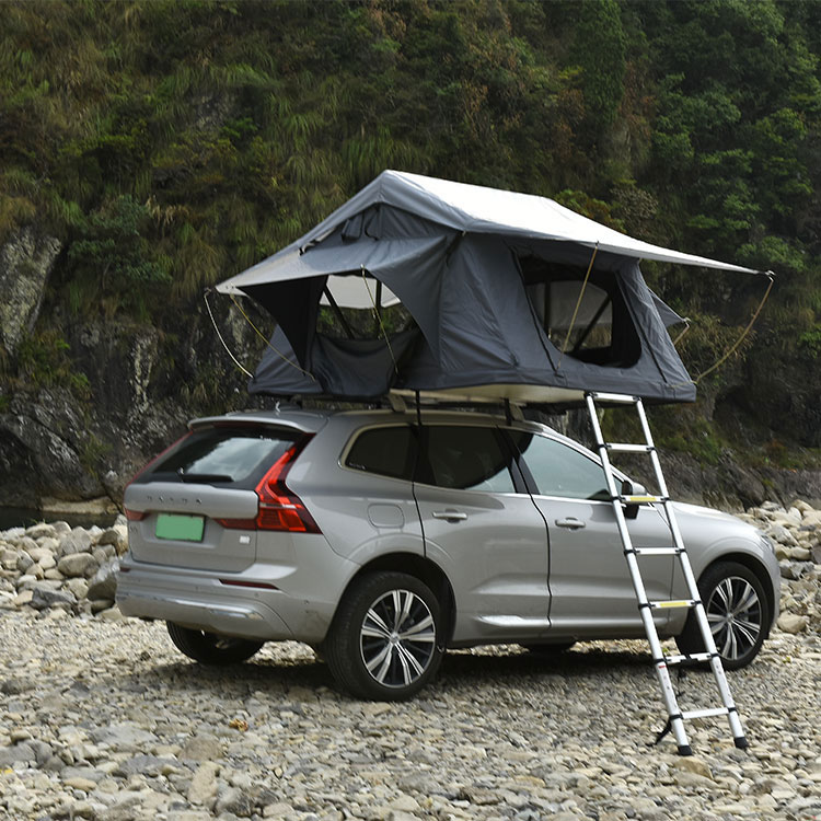 Silver SUV with grey soft shell rooftop tent deployed, automatic folding design with telescopic ladder and string lights, outdoor camping setup.